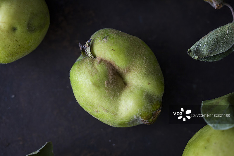 深色背景上的四个新鲜完整生 Quince图片素材