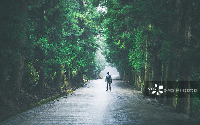 背着背包在路上行走的旅行者图片素材
