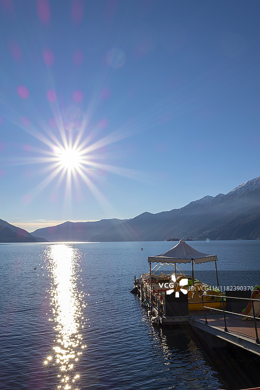 阳光和山脉下的高山湖泊上的脚踏船图片素材