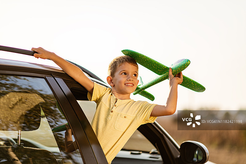 梦想着一个拿着飞机玩具的漂亮男孩图片素材