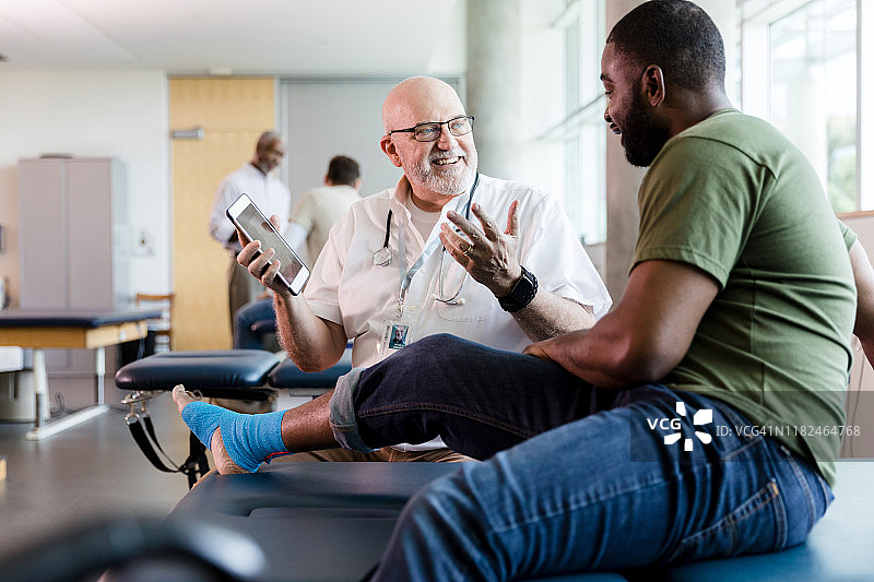 理疗师微笑地向退伍军人描述治疗方案图片素材