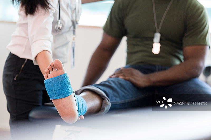 理疗师引导伸展时，无法辨认的退伍军人脚部特写图片素材