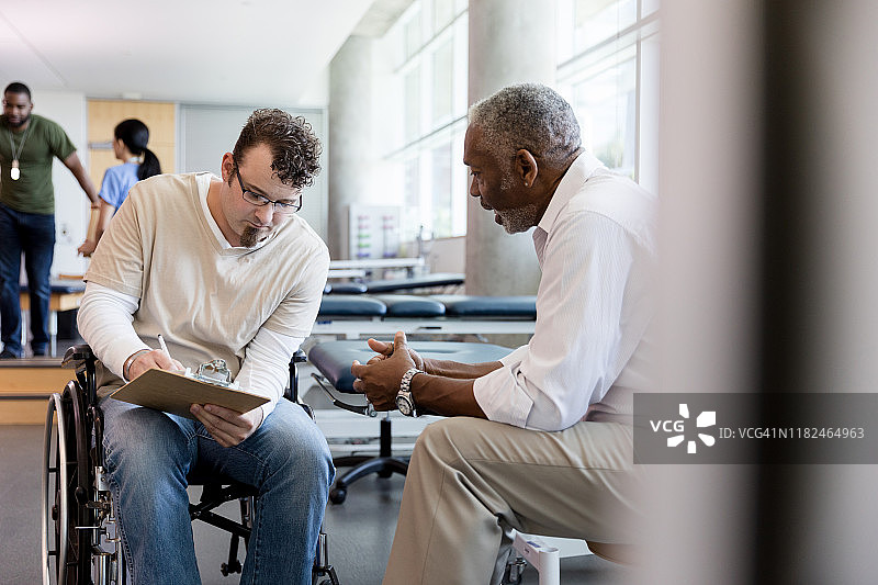 在康复中心填写文件的轮椅患者图片素材