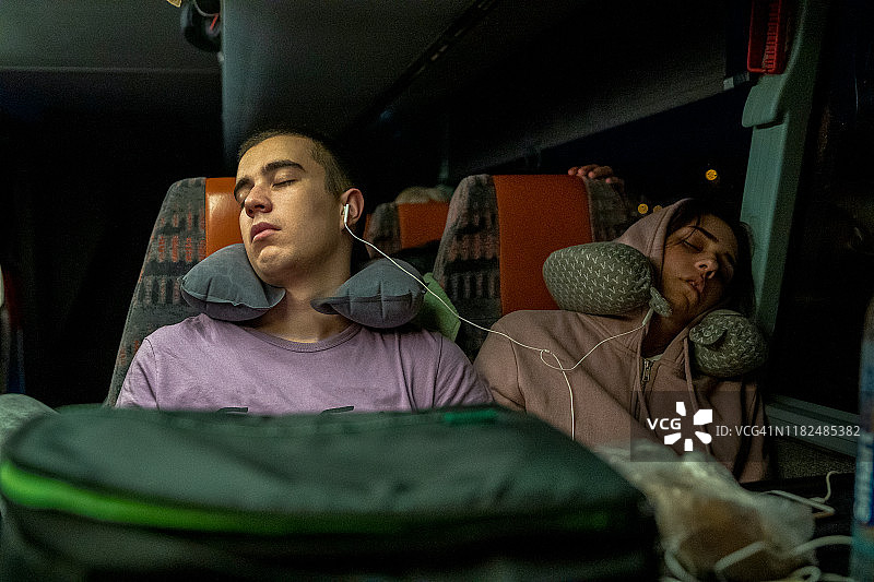 交通运输、旅游：旅行巴士上青少年情侣靠肩睡觉图片素材