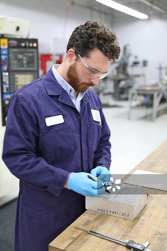 年轻的铣工测量金属块图片素材