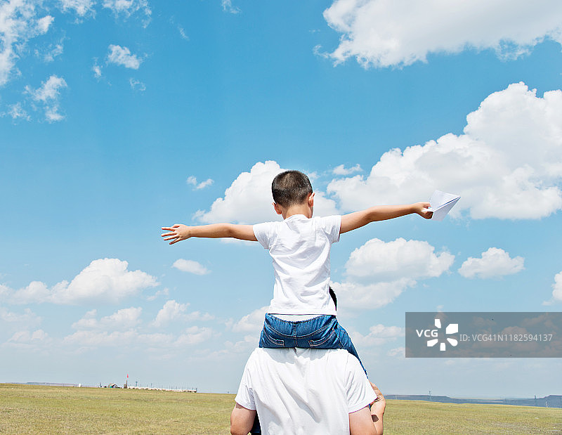 父子在田野里玩纸飞机图片素材