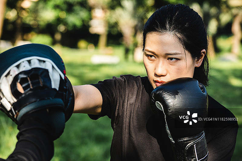 亚洲女性与伙伴在户外练习综合格斗图片素材