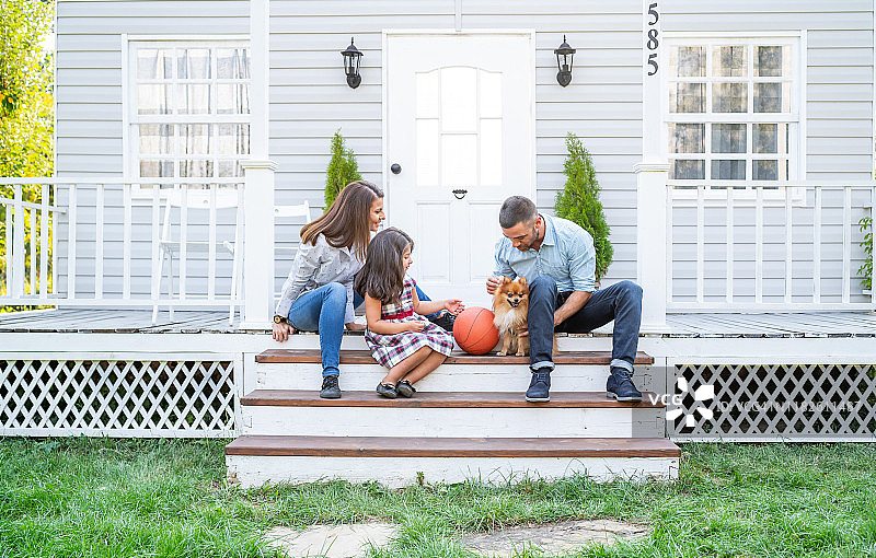 幸福的家庭：父母和两个孩子坐在美式门廊前图片素材