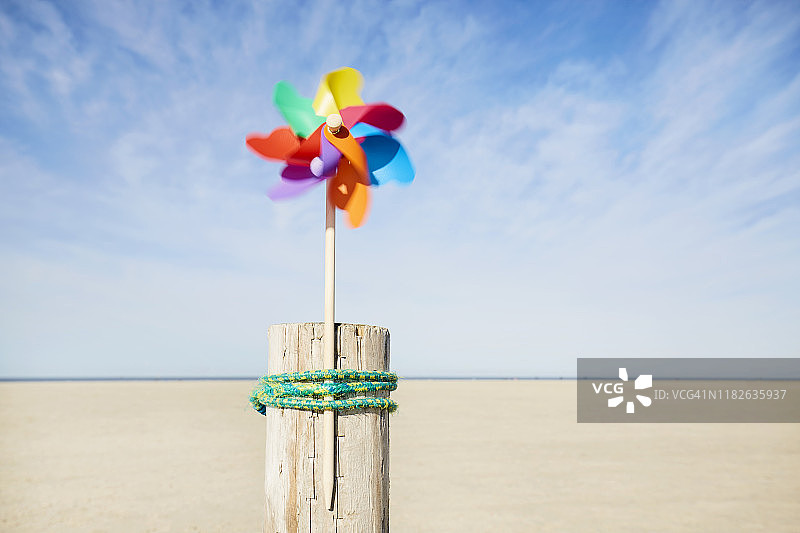 夏日海滩上映衬天空的彩色风车图片素材