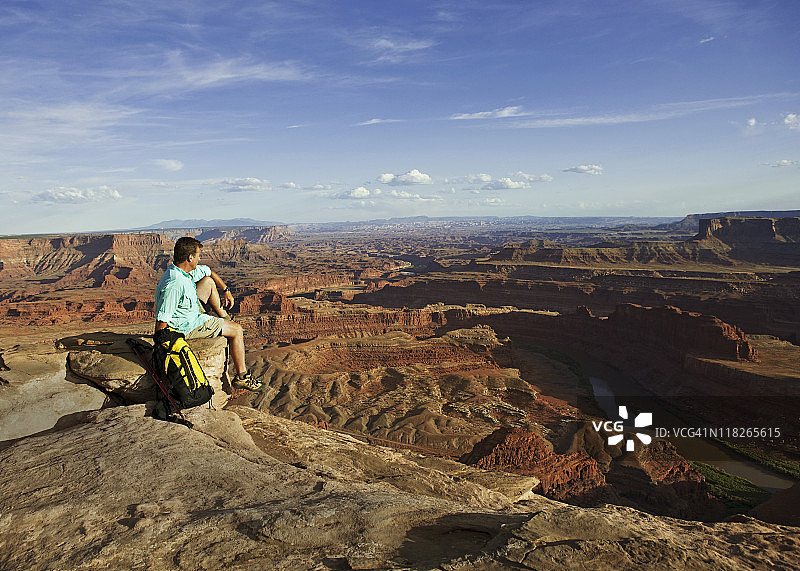 男人坐在岩石上眺望峡谷地貌图片素材