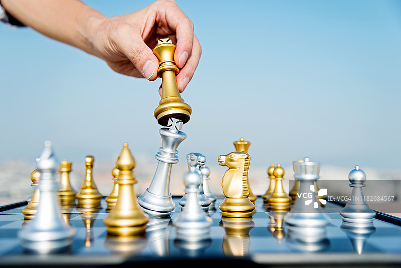 男人在象棋比赛中移动金色国王图片素材