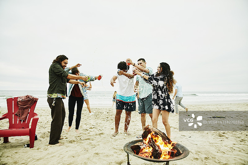 朋友们在海滩派对上开怀畅饮啤酒图片素材