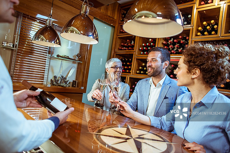 在酿酒厂的葡萄酒展示会上举杯庆祝的几代朋友图片素材