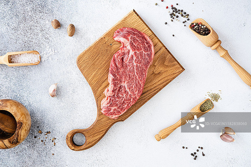 新鲜生牛肉丹佛牛排，配有胡椒粒、调味料和香料，可用于烧烤，顶视图图片素材