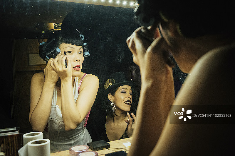 滑稽戏女演员在更衣室镜子前化妆准备图片素材
