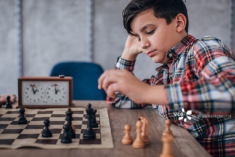 聪明的男孩独自练习国际象棋图片素材