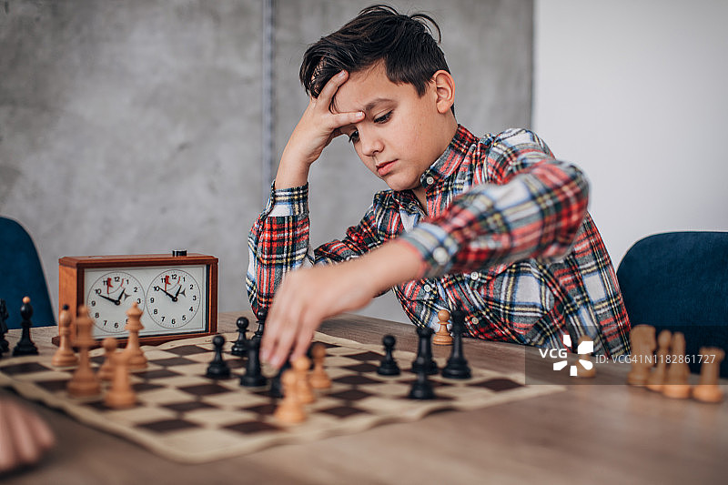 男孩独自练习国际象棋图片素材