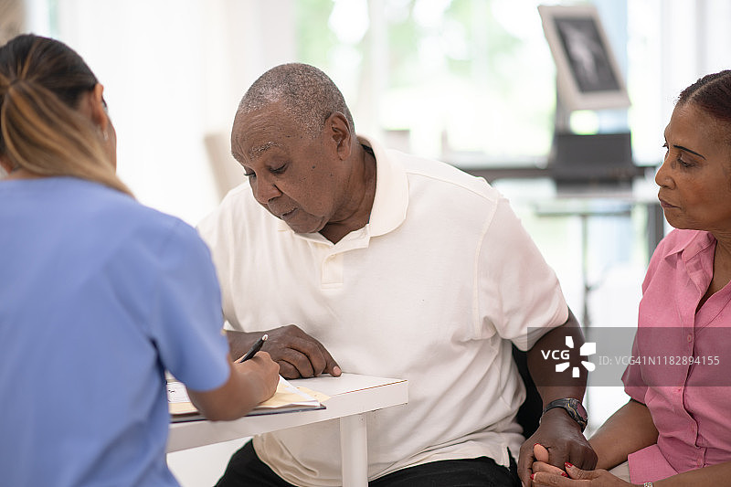 在医生办公室接受诊断的老年夫妇图片素材