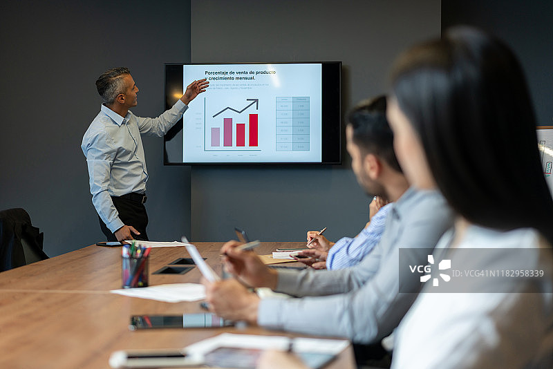 商务男士在会议中展示增长图表图片素材