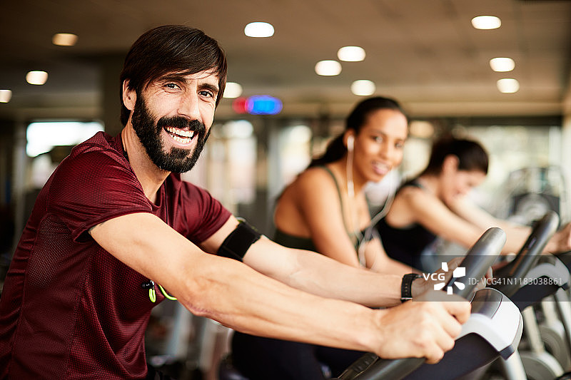 健身俱乐部里骑自行车的中年男人图片素材