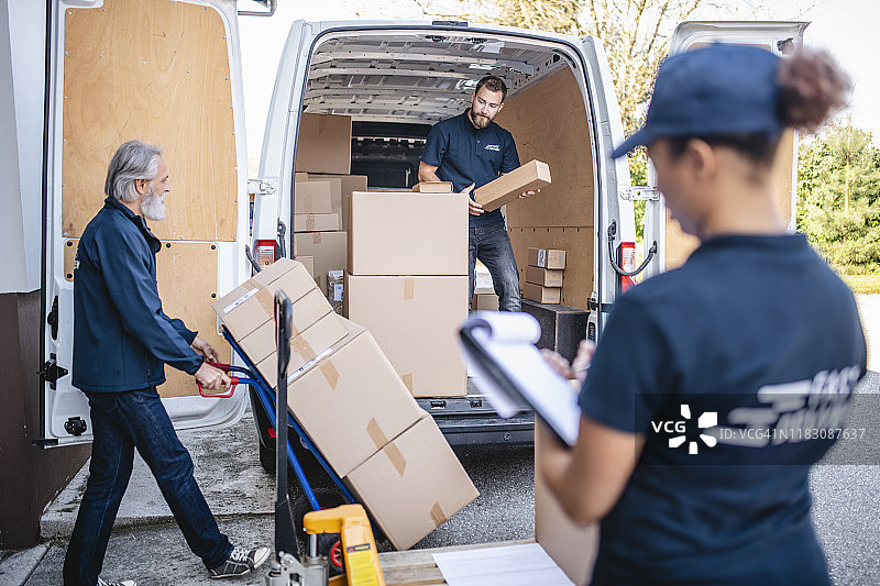 不同年龄段的零工团队在货车上装载包裹图片素材