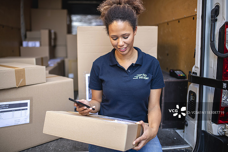 混血送货员检查包裹标签详情图片素材