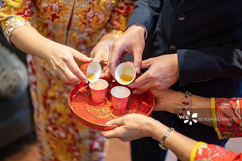 新婚夫妇在传统中式敬茶仪式上为长辈敬茶图片素材