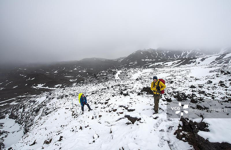 徒步者在新西兰汤加里罗国家公园的徒步道上穿过熔岩地图片素材