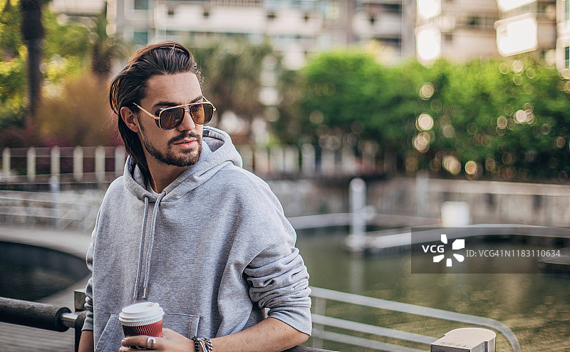 在城市里喝咖啡的时尚男人图片素材