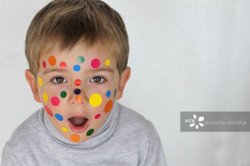 脸上贴着贴纸的幼儿图片素材