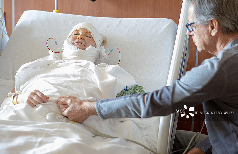 妇女与关心的丈夫脑和颈部手术后图片素材