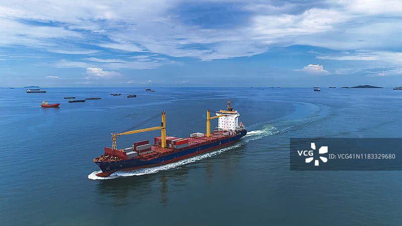 海上航行的货船航拍视角，集装箱船在白天晴朗的天空和美丽的大海中海上运输，泰国春武里府有各种驳船的海上交通图片素材