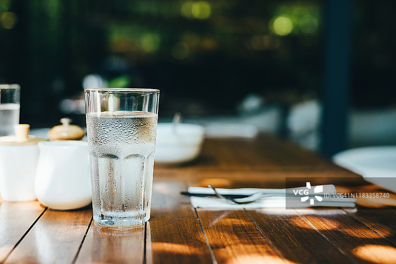 户外餐厅阳光下桌上的一杯水图片素材