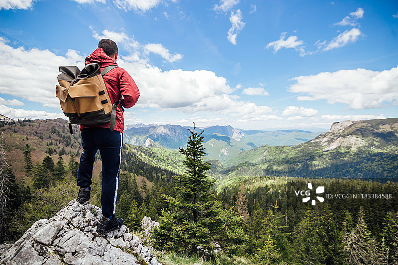 徒步旅行后，男子在山中的岩石上休息图片素材