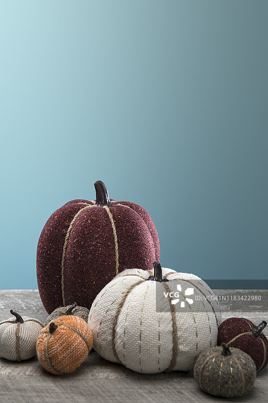 木纹蓝色背景上的秋季绗缝南瓜图片素材