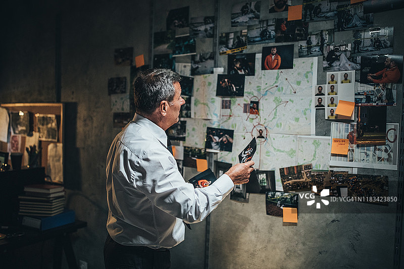 年长的侦探检查证据。图片素材