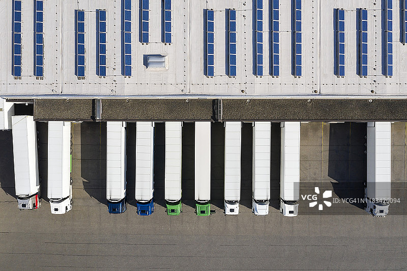 物流中心半挂卡车装货的鸟瞰图，配送仓库图片素材