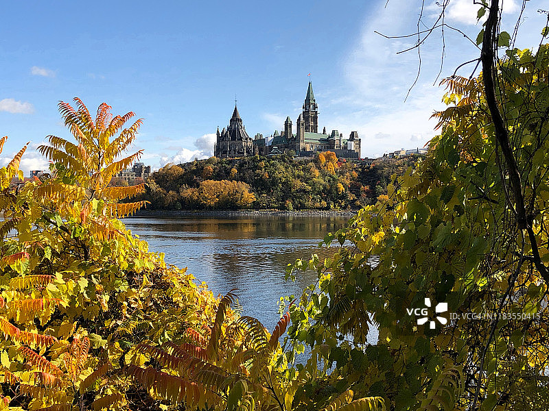 加拿大议会大厦秋景，渥太华河与阳光明媚的山丘图片素材