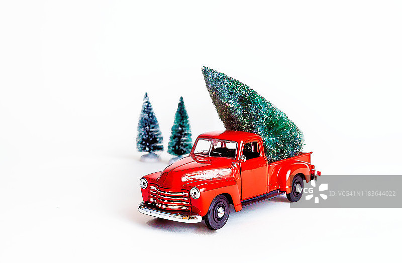白色背景上的复古红色卡车和圣诞树玩具图片素材