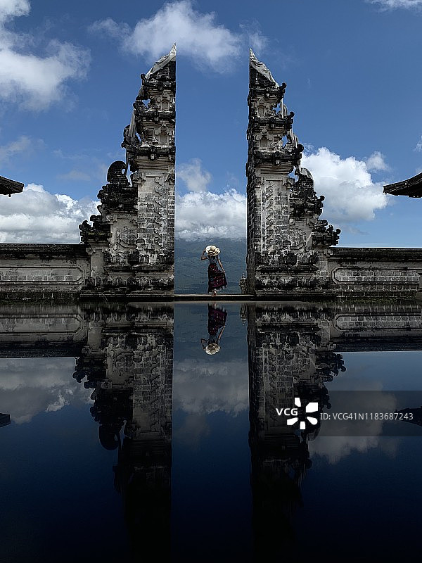 年轻女子站在巴厘岛伦普扬寺天堂之门前图片素材