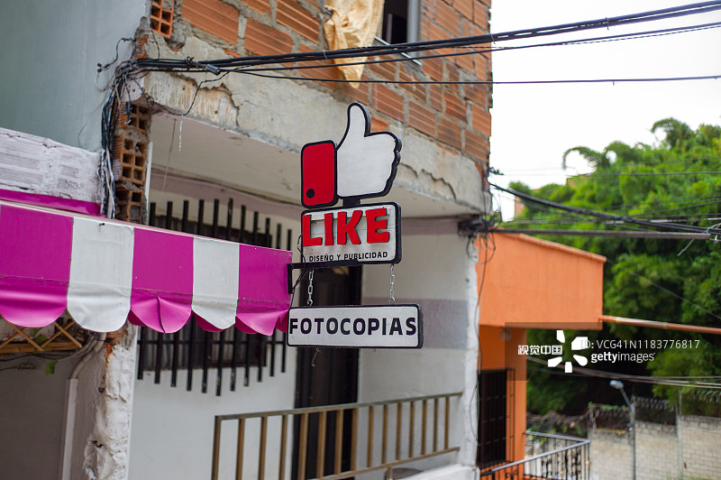 哥伦比亚安蒂奥基亚省麦德林 Comuna 13社区二楼的店铺提供设计、广告和复印服务图片素材