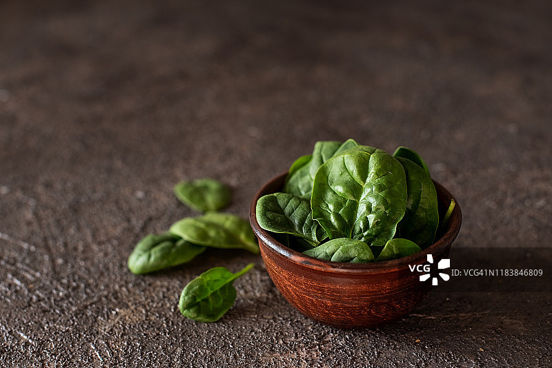 碗中新鲜菠菜叶，置于乡村木桌上（俯视）图片素材