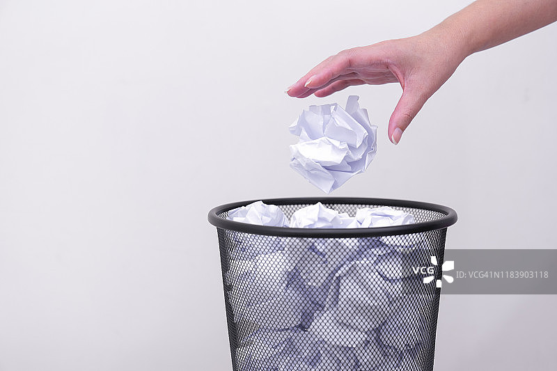 女人手将废纸扔进垃圾桶图片素材