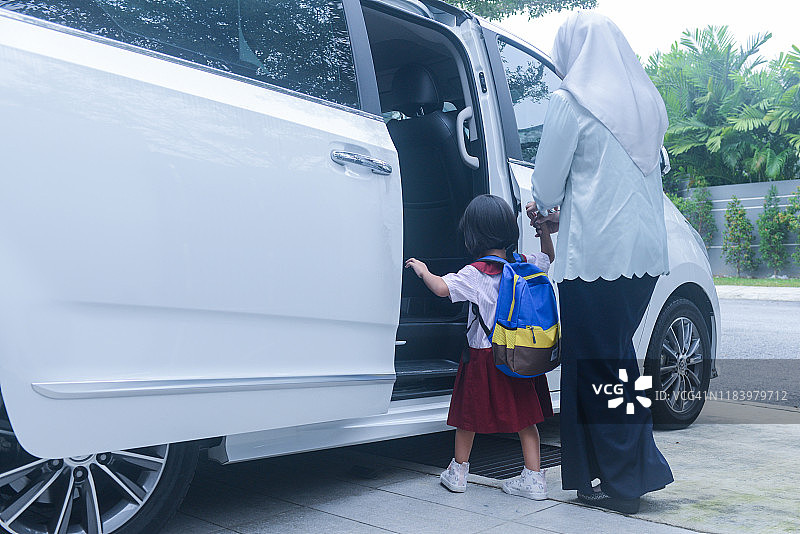 亚洲穆斯林年轻母亲送女儿上学，登上小型货车图片素材