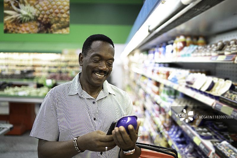 在超市购物并用智能手机扫描条形码的中年男人图片素材