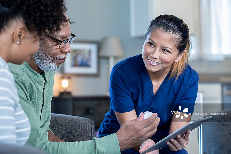 居家医疗护理人员与老年男性及其成年女儿图片素材