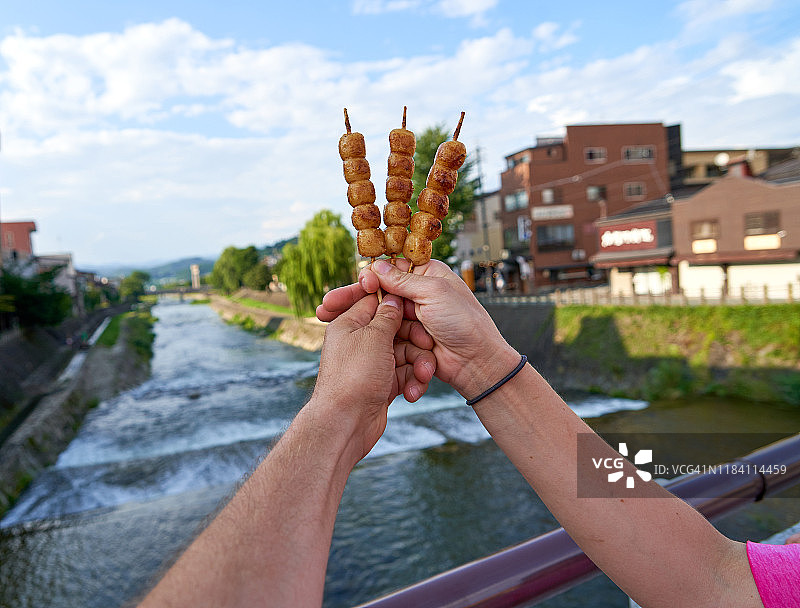游客展示日本街头食品丸子，京都浅野川大桥图片素材