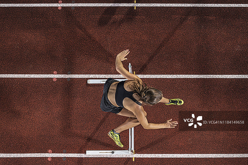 航拍女跑者田径跨栏图片素材