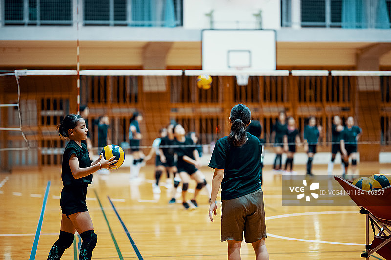 女教练指导年轻女孩排球训练图片素材