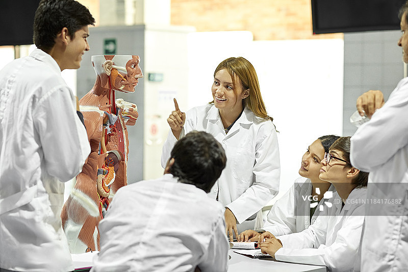 在解剖课上为朋友讲解的女人图片素材